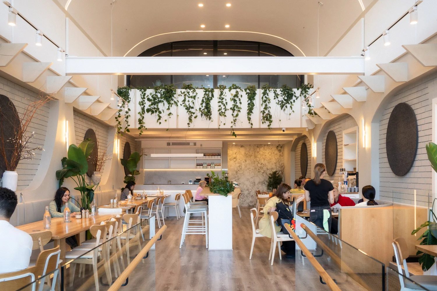 Inside Secret Grounds — light-filled dining room with hanging greenery